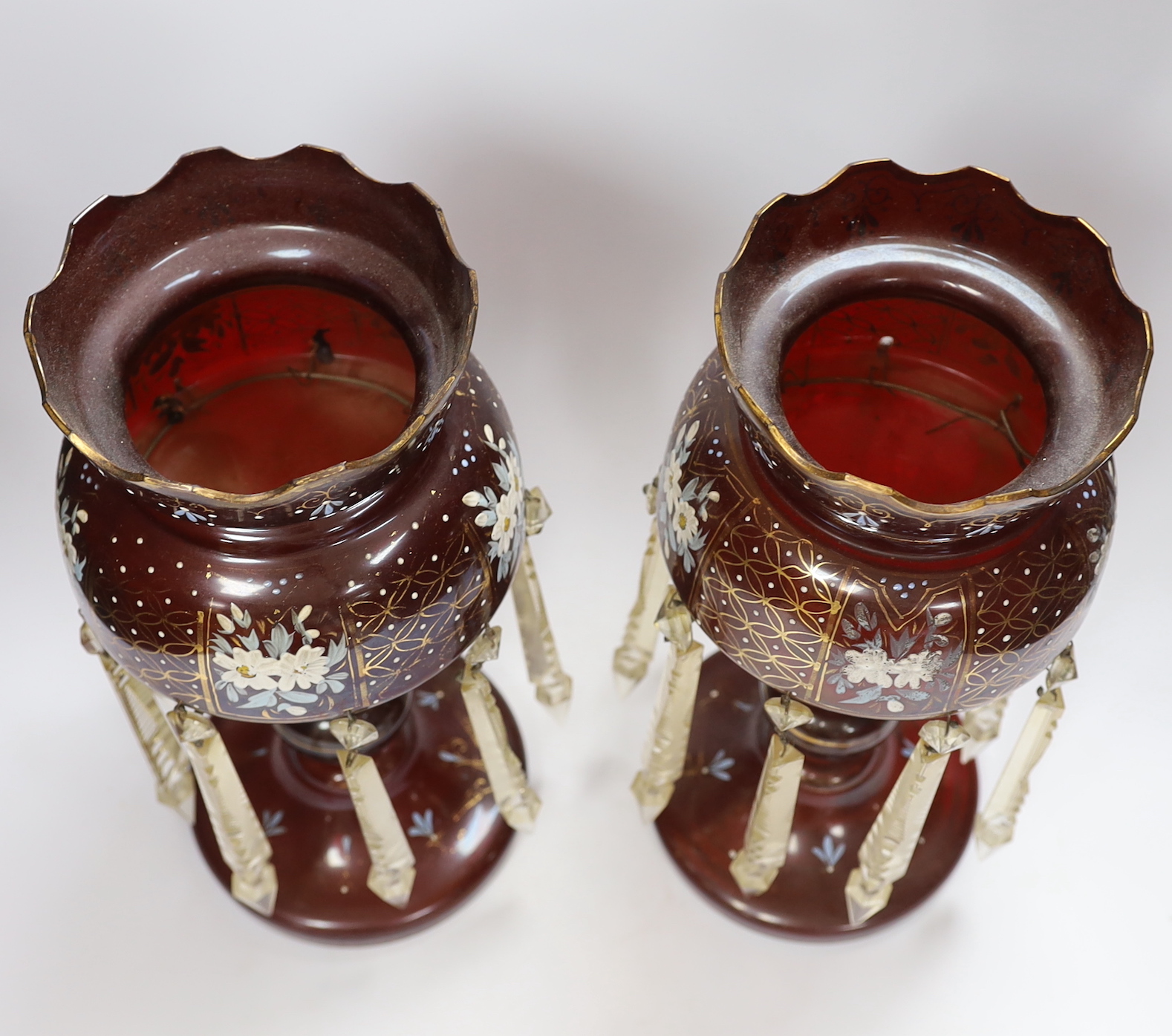 A pair of late 19th century ruby glass floral enamelled table lustres, 35.5cm high